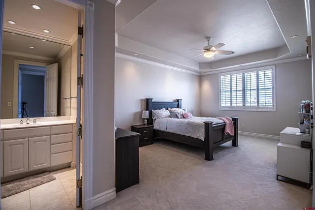 a bedroom with a bed and a chandelier fan