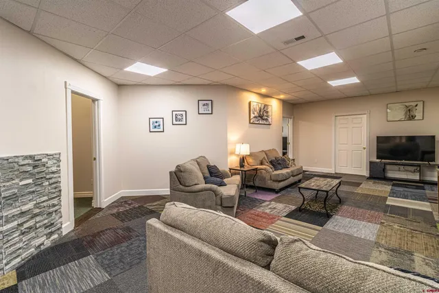 a living room with furniture a flat screen tv and a fireplace