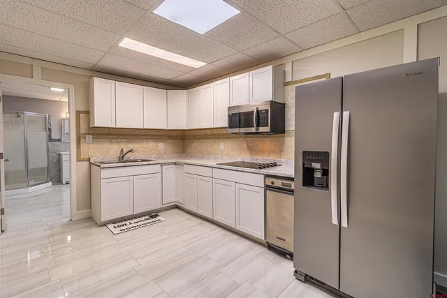 a kitchen with stainless steel appliances a refrigerator sink and microwave