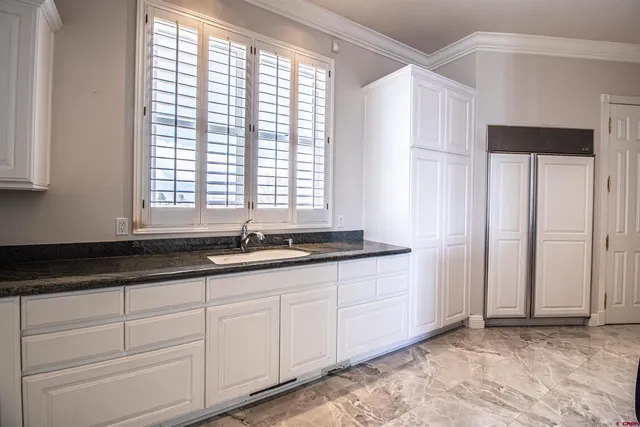 a kitchen with granite countertop white cabinets and white appliances