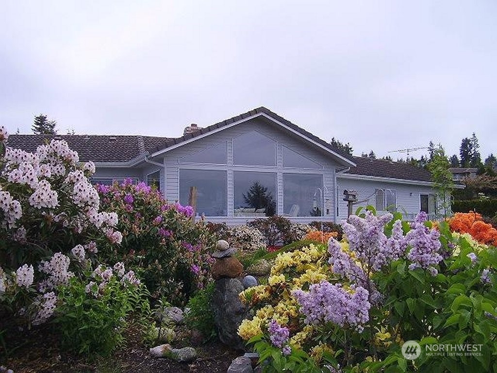 a view of a house with a lot of flower plants