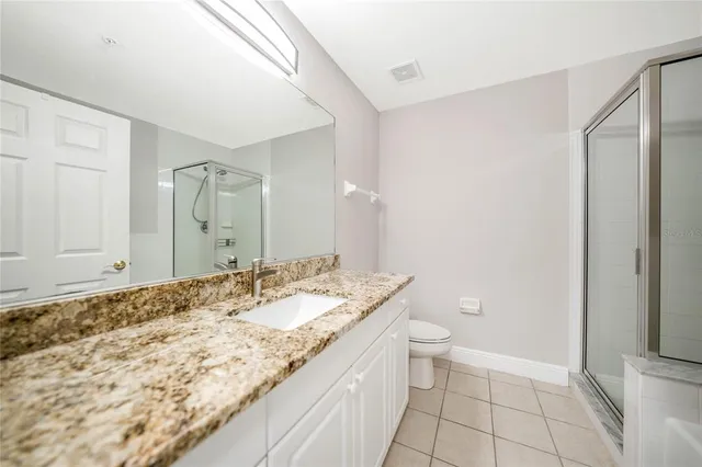 a bathroom with a granite countertop sink a toilet and a mirror