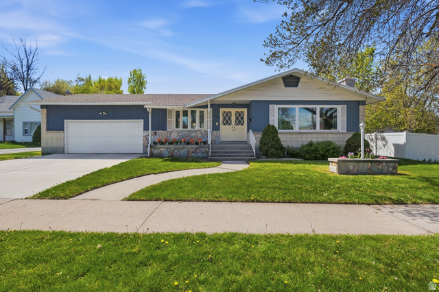 466 West 200 North Logan, UT 84321 - Photo 1 of 1 View of front of home with an attached garage, concrete driveway, brick siding, and a chimney