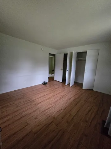 an empty room with wooden floor and window