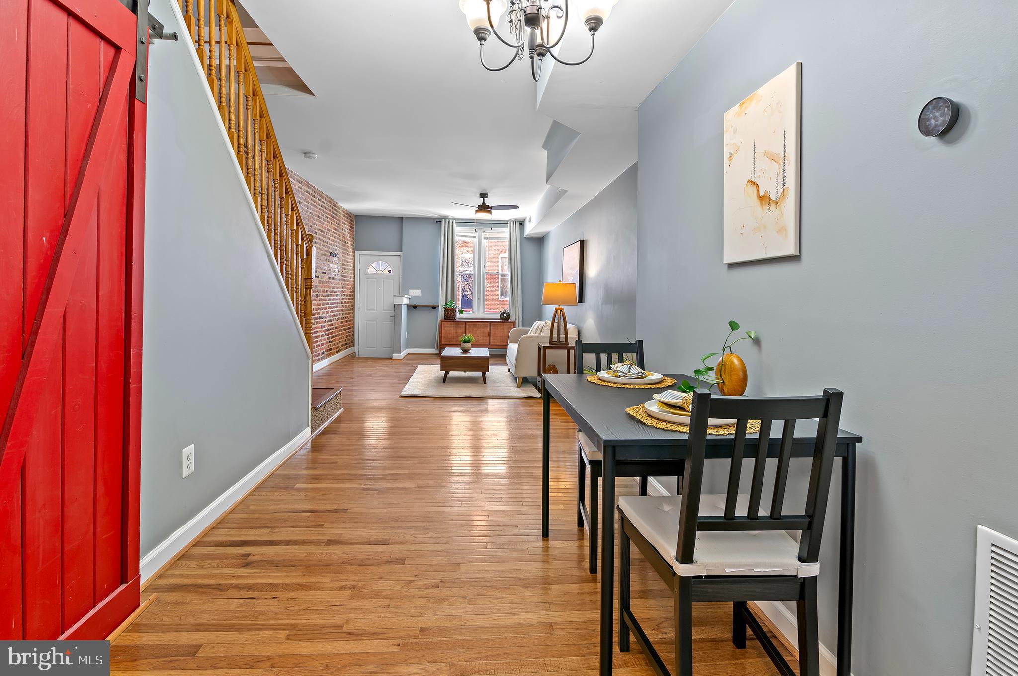 416 South Bouldin Street Baltimore, MD 21224 - Photo 12 of 45 a dining room with wooden floor a chandelier a wooden table and chairs