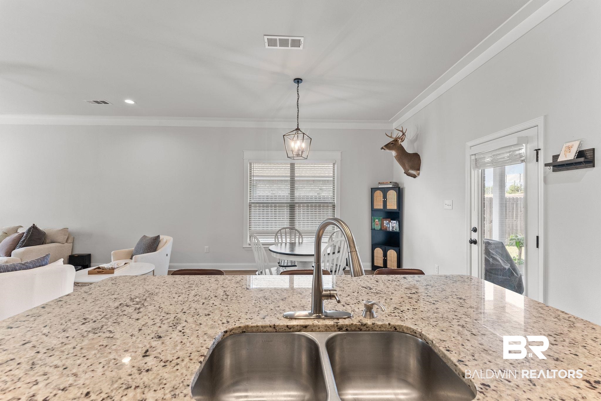10745 Brodick Loop Daphne, AL 36527 - Photo 38 of 39 Kitchen with crown molding, light stone counters, hanging light fixtures, and open floor plan