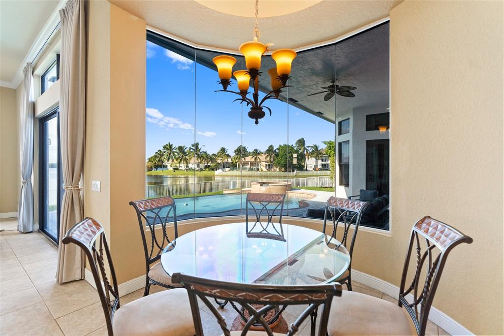 18622 Southwest 41st Street Miramar, FL 33029 - Photo 13 of 63 a dining room with wooden floor a chandelier a glass table and chairs