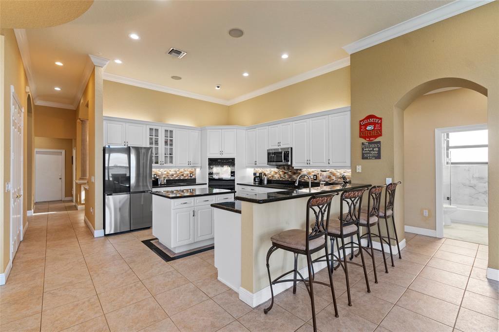 18622 Southwest 41st Street Miramar, FL 33029 - Photo 14 of 63 a kitchen with stainless steel appliances granite countertop a stove a sink a refrigerator and a dining table