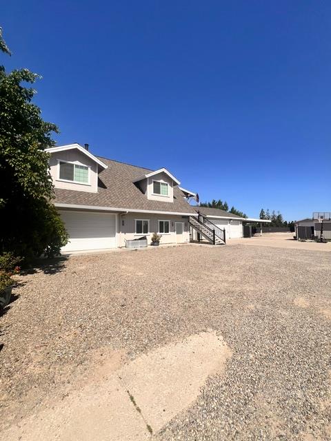 3019 Lathrop Road Manteca, CA 95336 - Photo 13 of 43 a front view of a house with a yard and garage