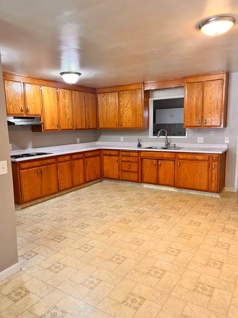 3019 Lathrop Road Manteca, CA 95336 - Photo 4 of 43 a large kitchen with kitchen island granite countertop a sink and a stove top oven with wooden floor