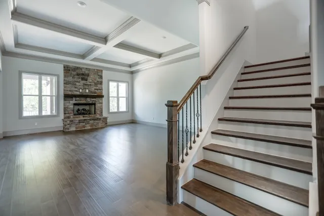 a view of a living room with wooden floor and a fireplace