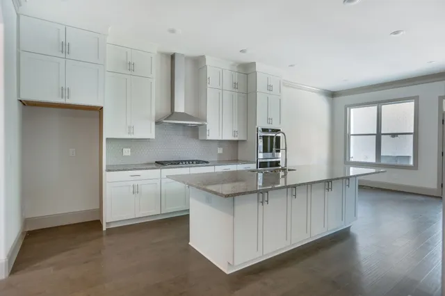 a kitchen with stainless steel appliances granite countertop a refrigerator a stove and a sink