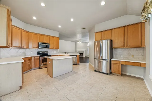 a kitchen with stainless steel appliances granite countertop a refrigerator sink stove microwave and cabinets