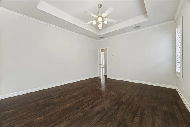 a view of an empty room with wooden floor