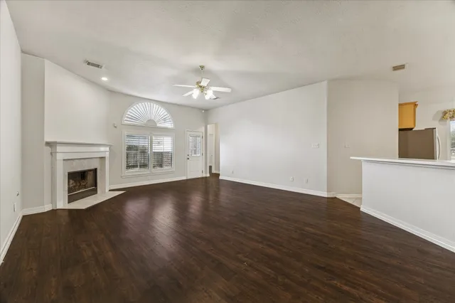 a view of a livingroom with a fireplace a chandelier and wooden floor