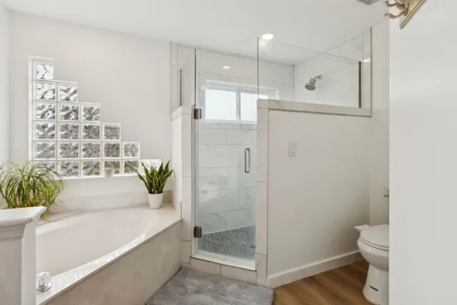 a bathroom with a bathtub shower and toilet