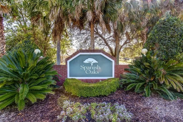 a sign that is sitting in front of a tree