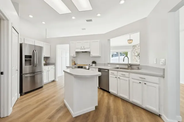 a kitchen with white cabinets and stainless steel appliances