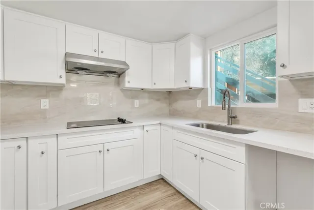 a kitchen with stainless steel appliances granite countertop a refrigerator sink and white cabinets