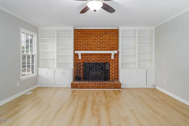 an empty room with windows dryer and fireplace