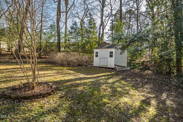 a view of a house with backyard and trees