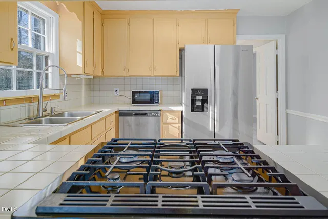 a kitchen with kitchen island granite countertop a stove and a sink