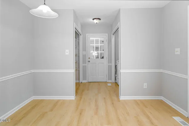 a view of empty room with wooden floor