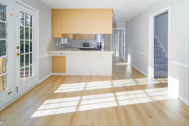 a view of a kitchen with kitchen island stainless steel appliances a sink and cabinets