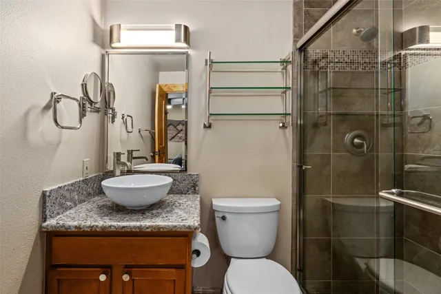 a bathroom with a granite countertop sink toilet and shower