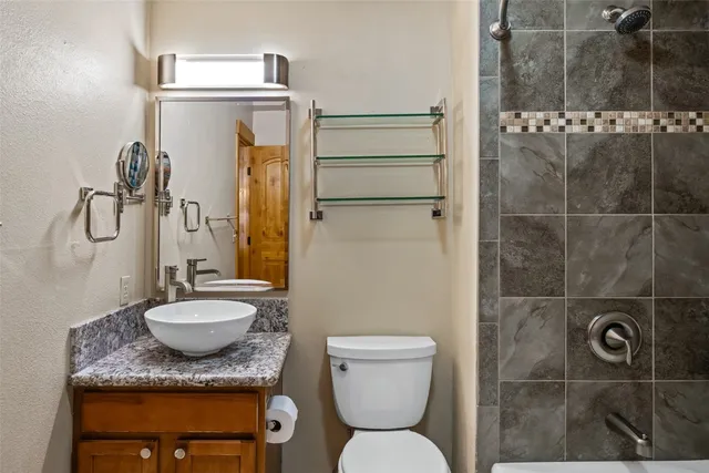 a bathroom with a granite countertop sink toilet and shower