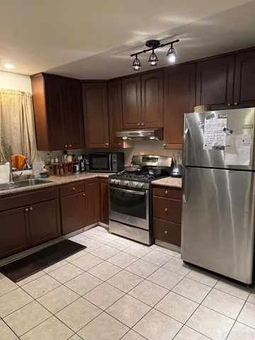 a kitchen with a refrigerator a stove a sink and cabinets