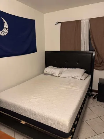 a bed sitting in a bedroom next to a window