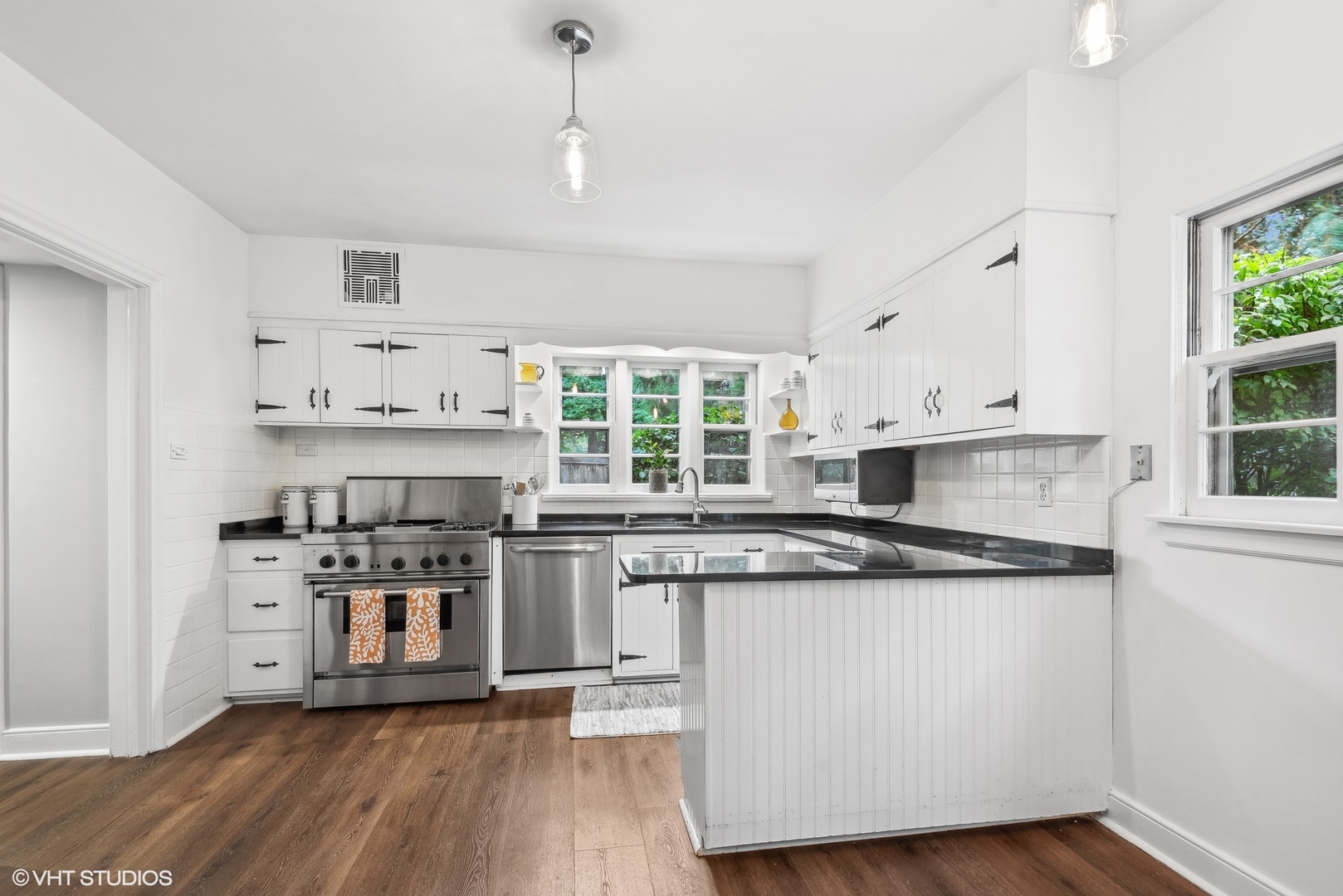 915 Pawnee Road Wilmette, IL 60091 - Photo 8 of 39 a kitchen with stainless steel appliances a stove a sink and white cabinets with wooden floor