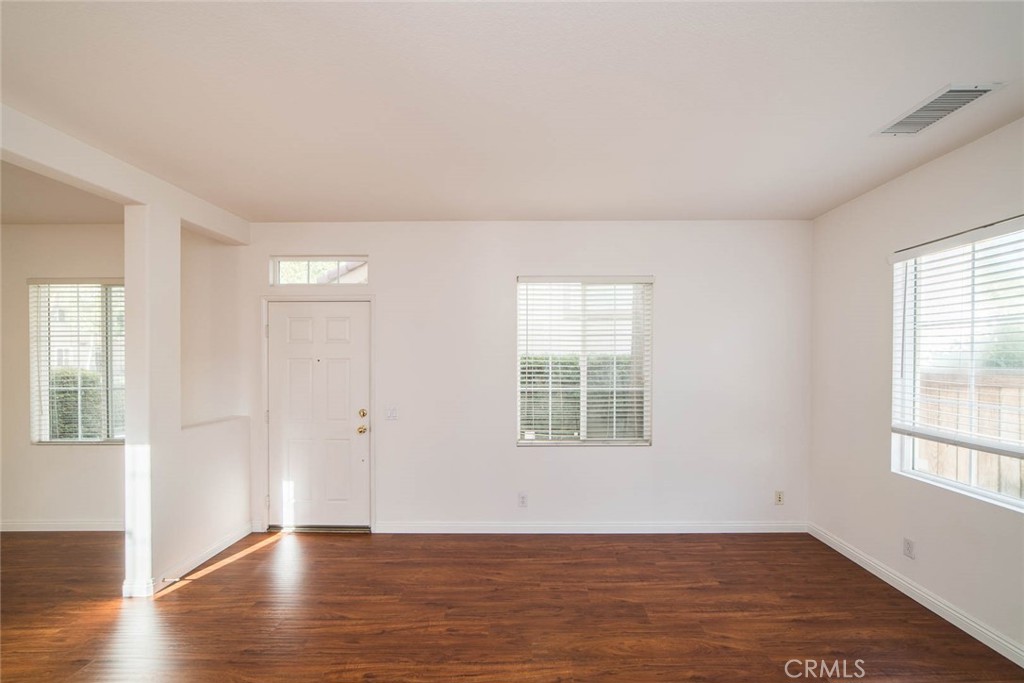 124 Cherrybrook Lane Irvine, CA 92618 - Photo 14 of 28 an empty room with wooden floor and windows