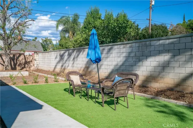 a view of a chair and table in backyard of the house