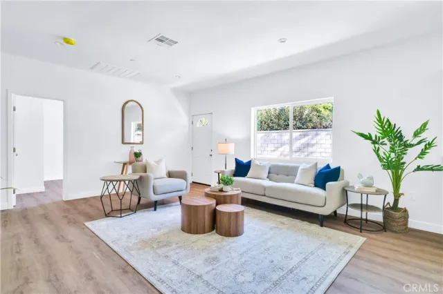 a living room with furniture potted plant and a wooden floor