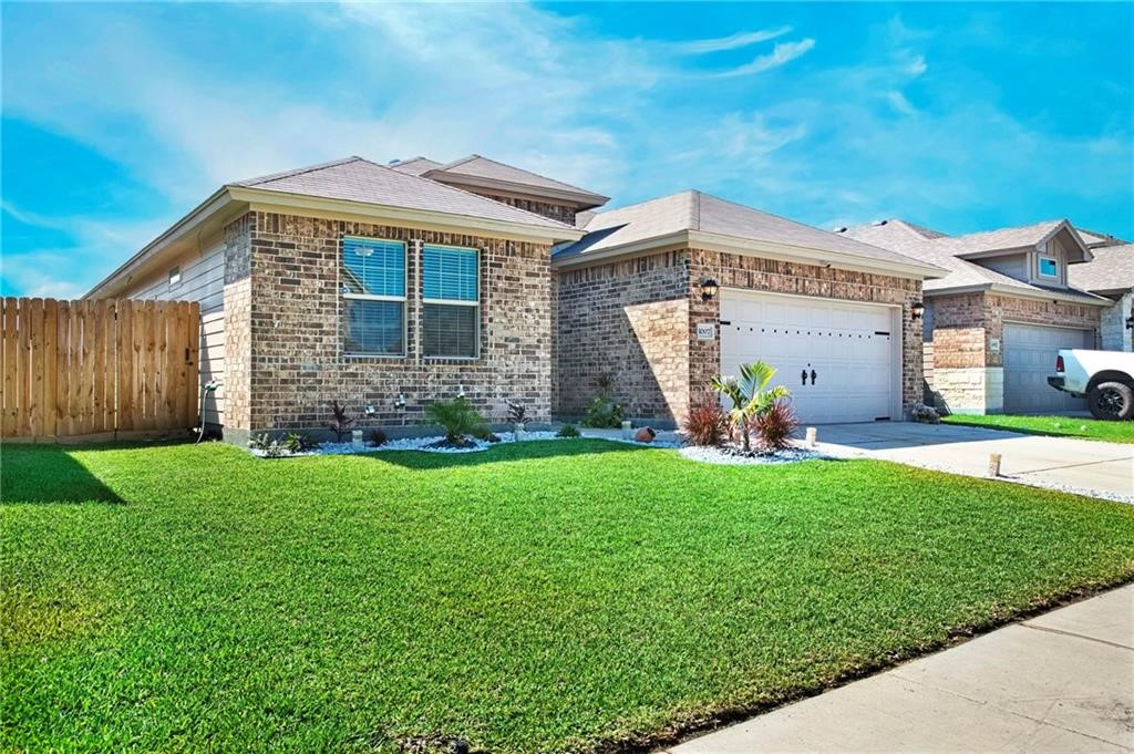1007 Ocean Breeze Portland, TX 78374 - Photo 3 of 17 a front view of a house with a garden and plants