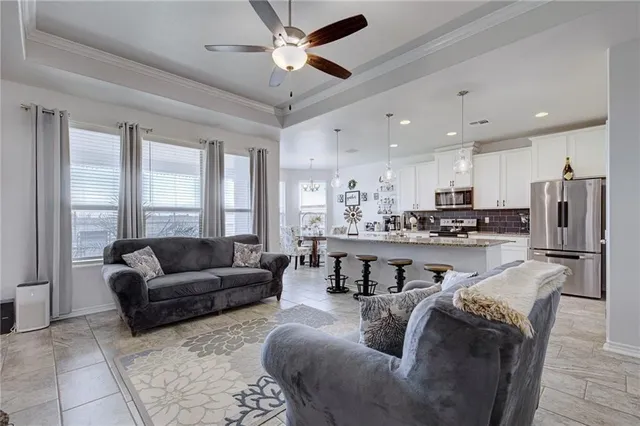 a living room with stainless steel appliances kitchen island granite countertop furniture and a large window