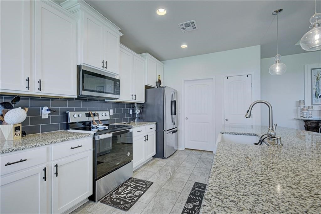 1007 Ocean Breeze Portland, TX 78374 - Photo 8 of 17 a kitchen with stainless steel appliances granite countertop a sink a stove a refrigerator cabinets and a window