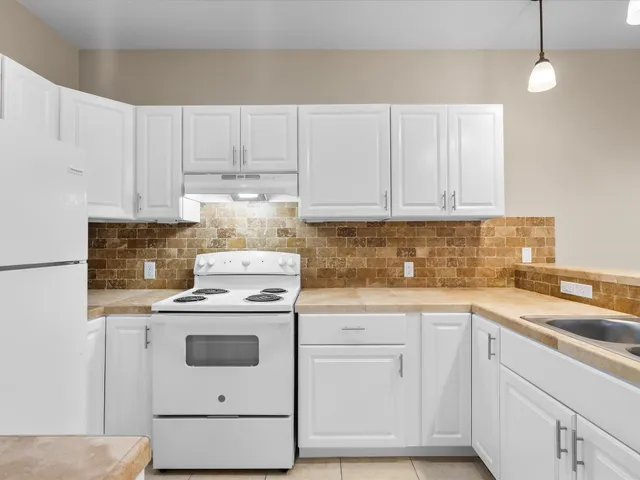 a kitchen with cabinets appliances a sink and a counter top