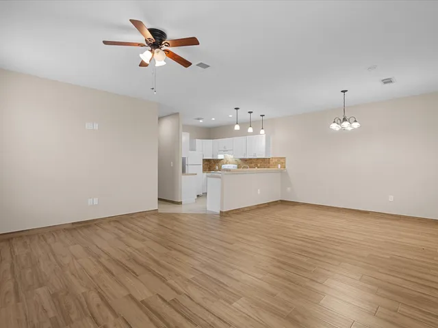 wooden floor in an empty room with a kitchen