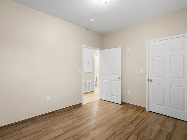 a view of an empty room with wooden floor