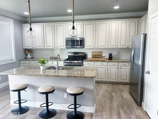 a kitchen with stainless steel appliances granite countertop a sink refrigerator and cabinets