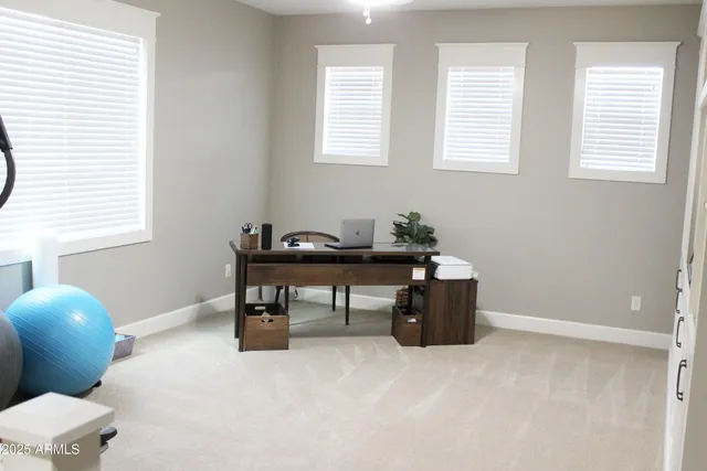 a view of a bedroom with wooden floor and windows