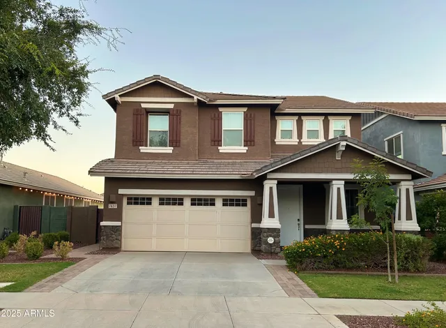 a front view of a house with a yard and trees