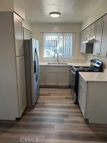 a kitchen with stainless steel appliances granite countertop a refrigerator a stove a sink and a microwave