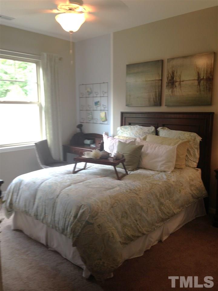 826 Wickham Ridge Road, Unit 6 Apex, NC 27539 - Photo 15 of 25 a bed sitting in a bedroom next to a window