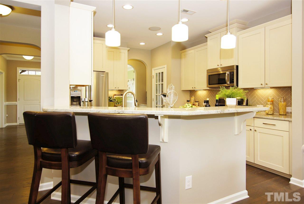 826 Wickham Ridge Road, Unit 6 Apex, NC 27539 - Photo 6 of 25 a kitchen with a table chairs sink and cabinets