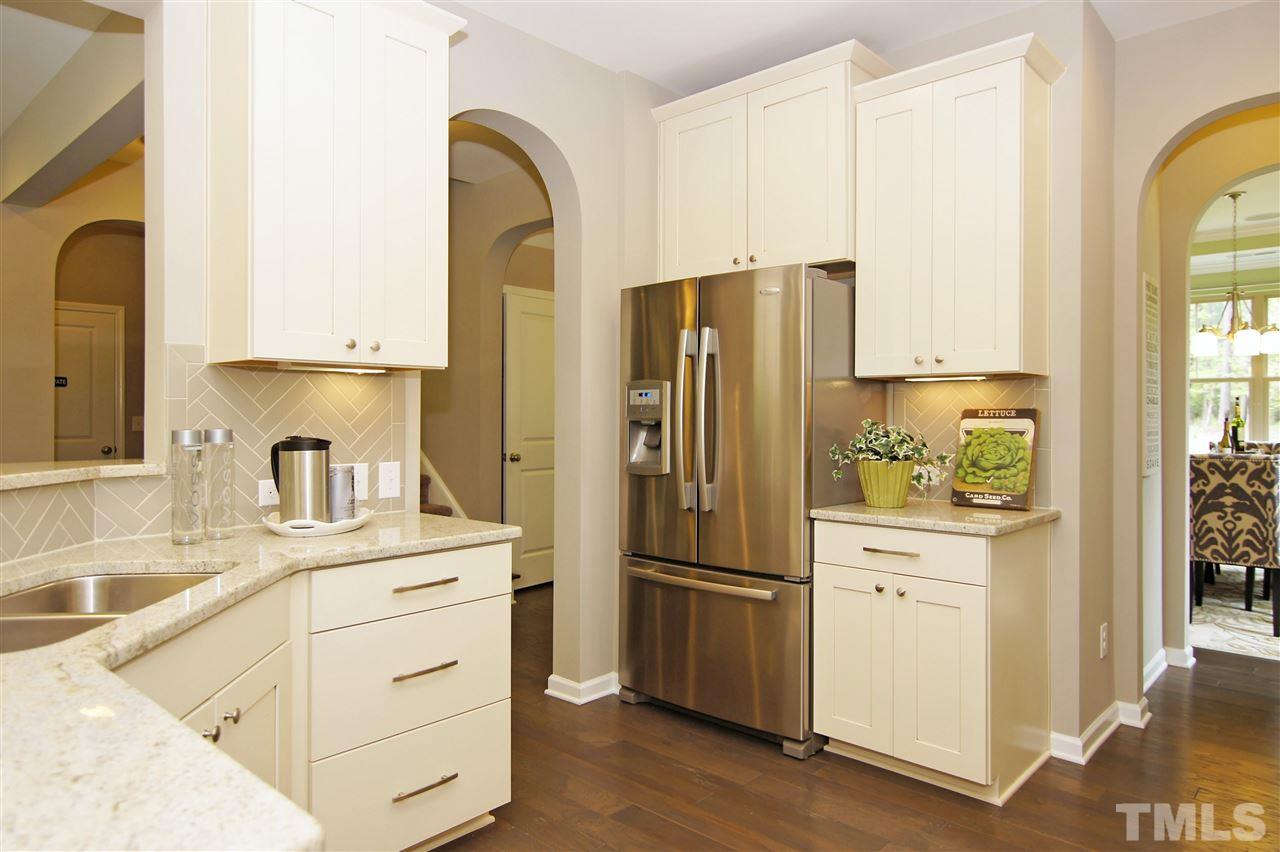 826 Wickham Ridge Road, Unit 6 Apex, NC 27539 - Photo 7 of 25 a kitchen with a refrigerator sink and cabinets