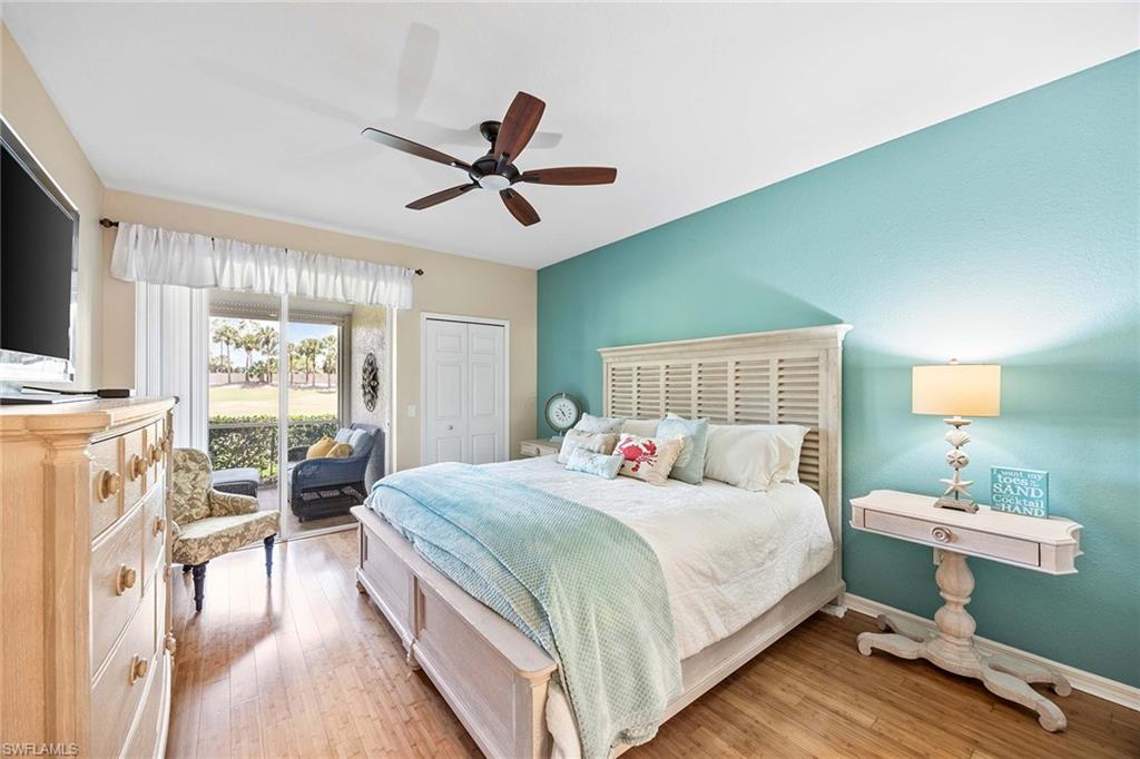 7000 Pinnacle Lane, Unit 1401 Naples, FL 34110 - Photo 13 of 49 a bedroom with a bed a chandelier and a flat screen tv